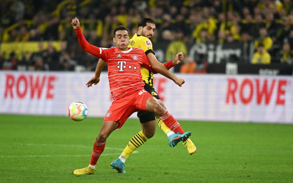 Emre Can og Jamal Musiala kæmper om bolden i Bundesliga-kampen mellem Dortmund og Bayern München.