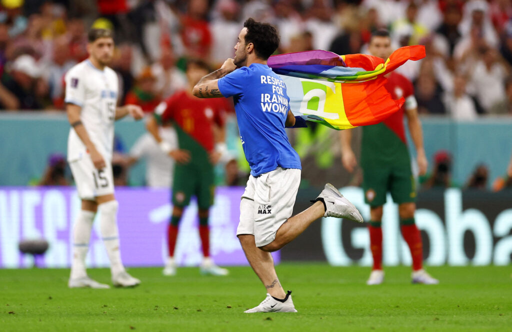 En baneløber med regnbueflag løb på banen ved VM i Qatar 2022 under kampen mellem Portugal og Uruguay den 28. november.
