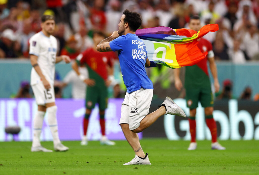 En baneløber med regnbueflag løb på banen ved VM i Qatar 2022 under kampen mellem Portugal og Uruguay den 28. november.