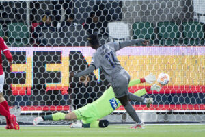 Franculino i den grå trøje sender bolden i mål bag Nicolai Larsen i den grønne trøje.