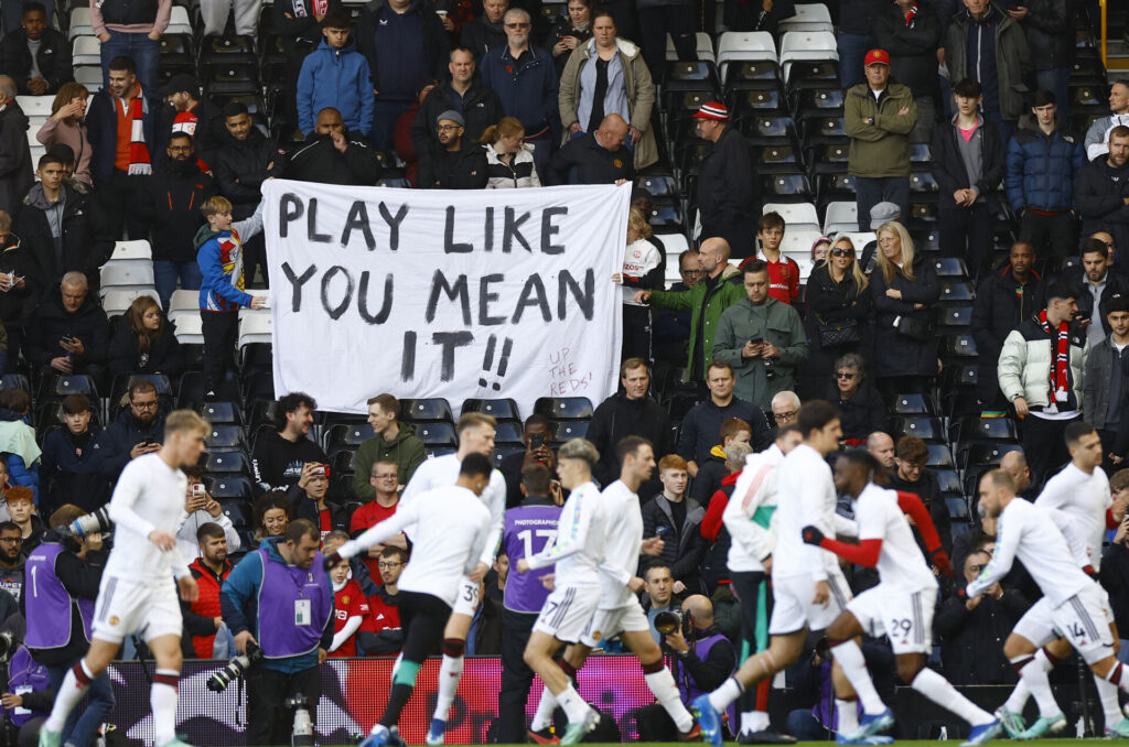 Manchester Uniteds spillere varmer op under skilt fra fan