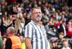 Peter Lassen står med hænderne i lommen foran Hvidovres tribune