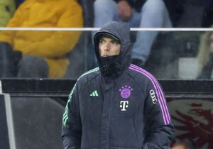 Thomas Tuchel står pakket ind i tøj og i regn