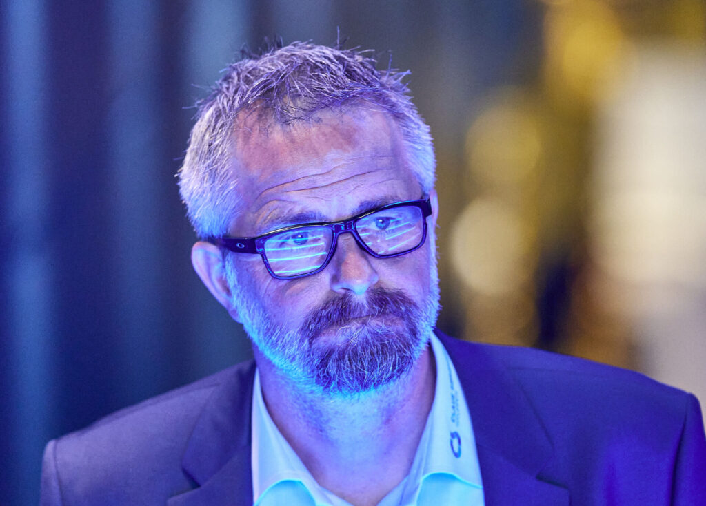 Jens Hammer Sørensen i blåt lys og med briller