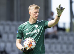 Mads Kikkenborg iført grøn trøje og med en bold i hænderne