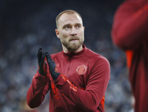 Eriksen klapper ud til publikum iført rødt tøj