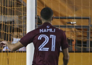 Namli iført en trøje foran et fodboldmål