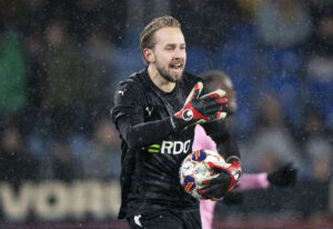 Carlgren holder en bold iført sort trøje