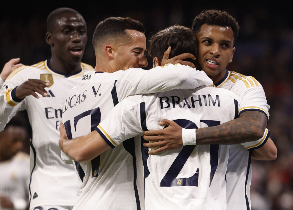 Fire Real Madrid-spillere fejrer en scoring iført deres hvide trøjer.