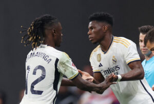 To spillere i hvide trøjer klapper hinanden i hånden