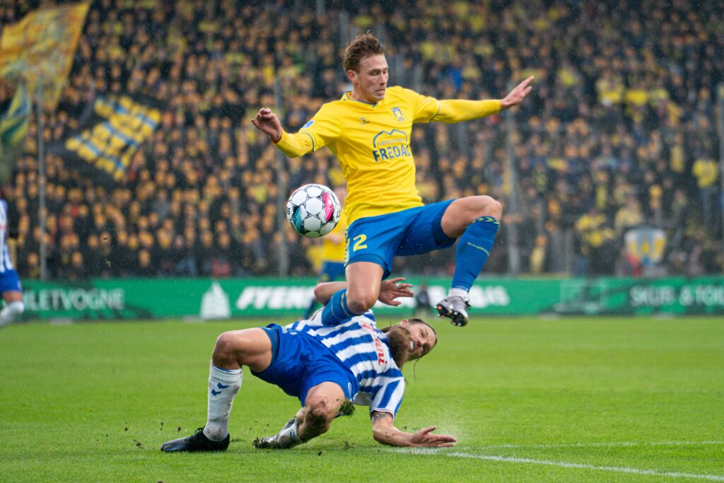 Bjørn Paulsen tackler Sebastian Sebulonsen i superliga-kampen mellem OB og Brøndby