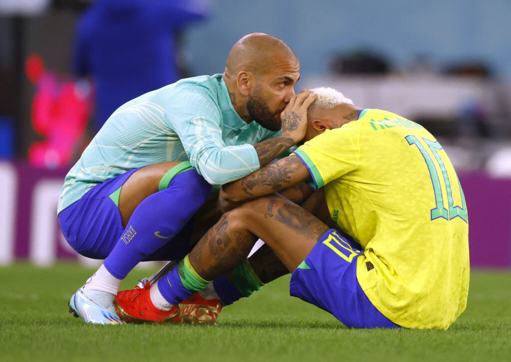 Neymar hjælper Dani Alves efter dom.