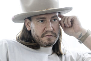 Nicklas Bendtner sidder med hat og ur i forbindelse med interview