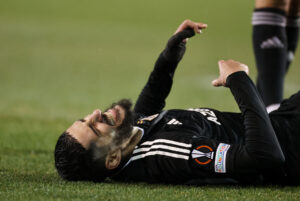 Yassine Benzia ligger på græsset under Europa League kampen imellem Qarabag og Bayer Leverkusen.