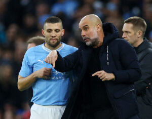 Mateo Kovacic er i færd med at få taktiske informationer af cheftræner Pep Guardiola.