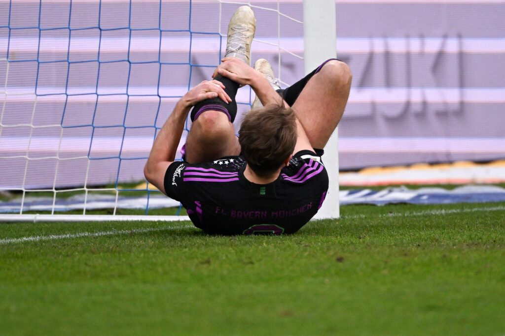 Bayern Münchens Harry Kane tager sig til anklen i smerte.
