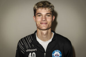 Alexander Busch smiler for kameraet.