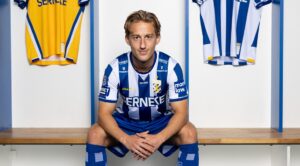 Arbnor Mucolli sidder på bænken i omklædningsrummet med IFK Göteborg trøjer til hver side.