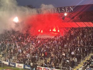 OB's fans holder et banner og romerlys op på tribunen