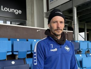 Mike Jensen står på tribunen på HB Køges hjemmebane.