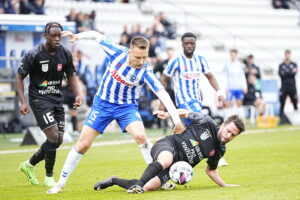 En ob-spiller i duel med en Hvidovre spiller.