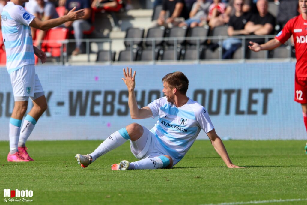 En FC Helsingør-spiller ligger i græsset i kamp i NordicBet Ligaen mod FC Fredericia