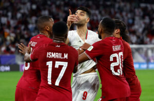 Irans Mehdi Taremi i klammeri med spillere fra Qatar.