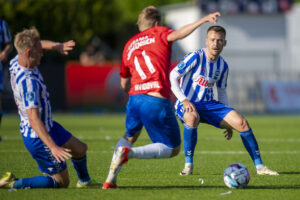 Tom Trybull fra OB i duel med Hvidovre-spiller.