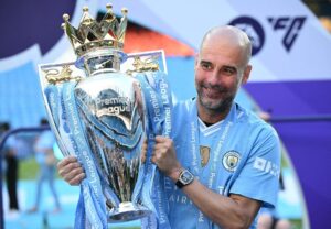 Pep Guardiola løfter Premier League-trofæet.