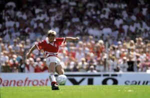 John Helt sparker til bolden iført den danske landsholdstrikot. Danmarks trup ved EM 1988