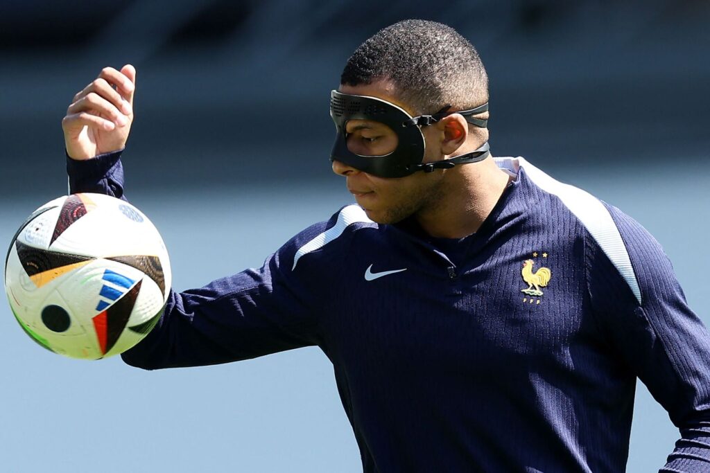 Kylian Mbappé jonglerer med bold og maske på.