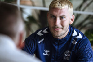 Jonas Wind sidder og snakker i den danske landsholdslejr.