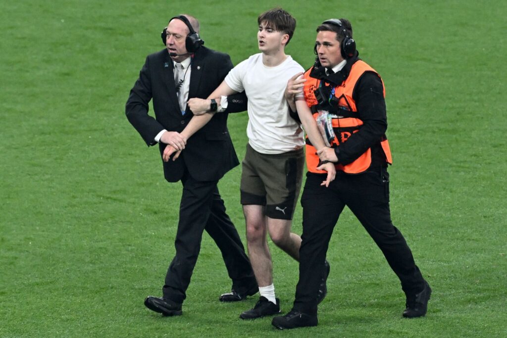 En baneløber bliver ført ud af vagterne under Champions League-finalen mellem Real Madrid og Dortmund.
