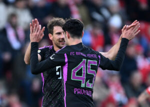 Aleksandar Pavlovic giver highfive til en holdkammerat i FC Bayern München.