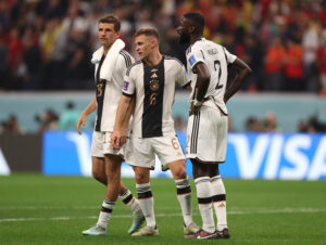 Tre tyske spillere står på banen efter en fodboldkamp