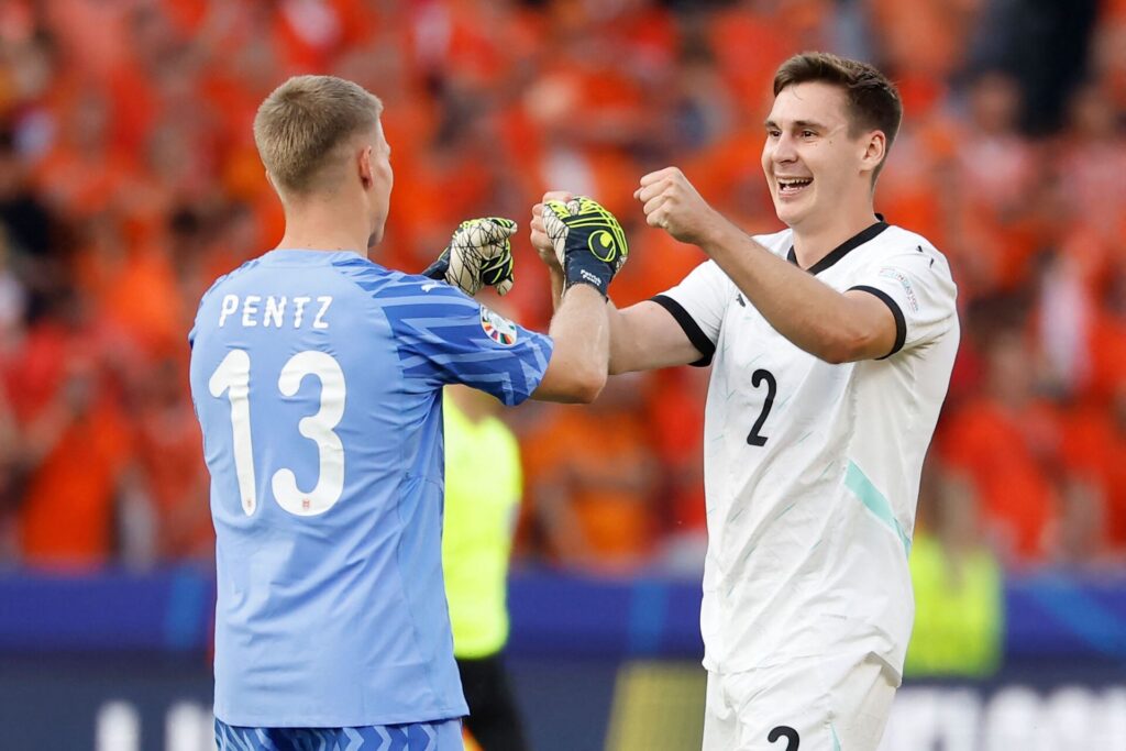 Patrick Pentz jubler med østrigsk forsvarspiller efter sejren over Holland