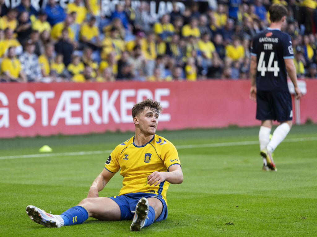 Mathias Kvistgaarden sidder på græssen under Brøndby IF's kamp mod Randers FC.