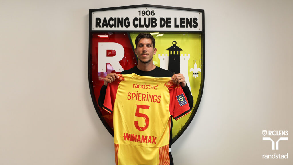 Stijn Spierings poserer foran RC Lens' logo med klubbens gule trøje