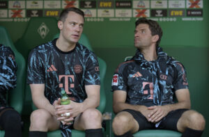Manuel Neuer og Thomas Müller sidder på bænken for Bayern München.