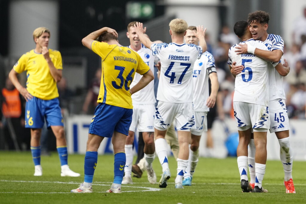 Mathias Kvistgaarden står foran FCK-spillere, der fejrer derbysejr.