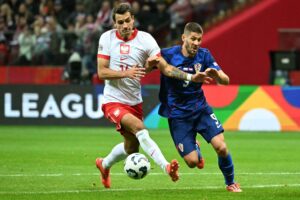 Polens Jakub Kiwior i kamp om bolden mod Kroatiens Andrej Kramaric