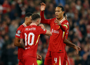 Virgil van Dijk jubler med to af sine holdkammerater i Liverpool.