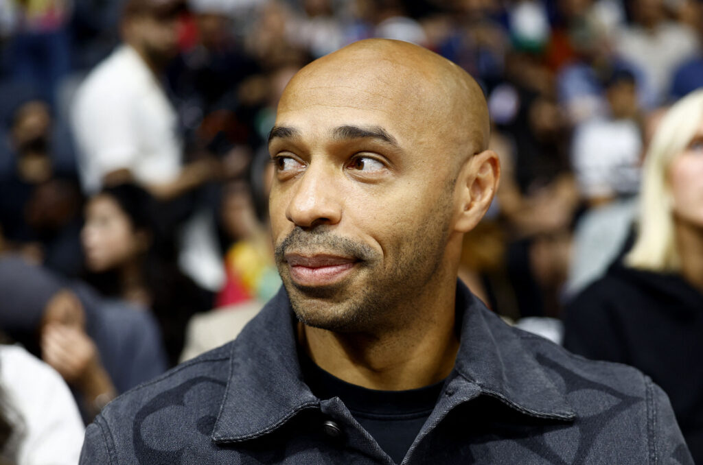 Thierry Henry kigger fra tilskuerrækkerne til en basketkamp i USA