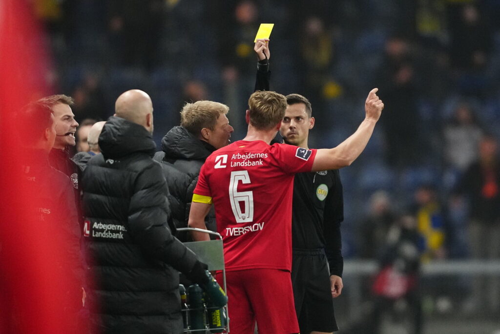 Dommer Lasse Graagard giver FCN's Jeppe Tverskov gult kort.