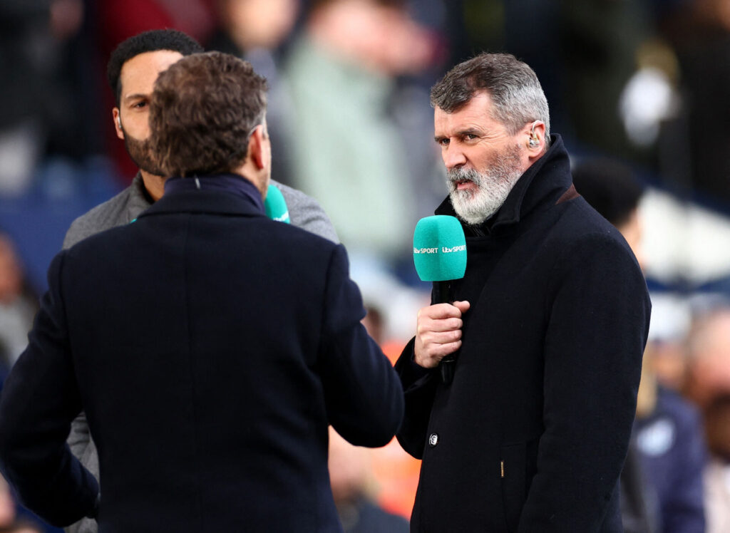 Roy Keane skuler, imens han holder en mikrofon.