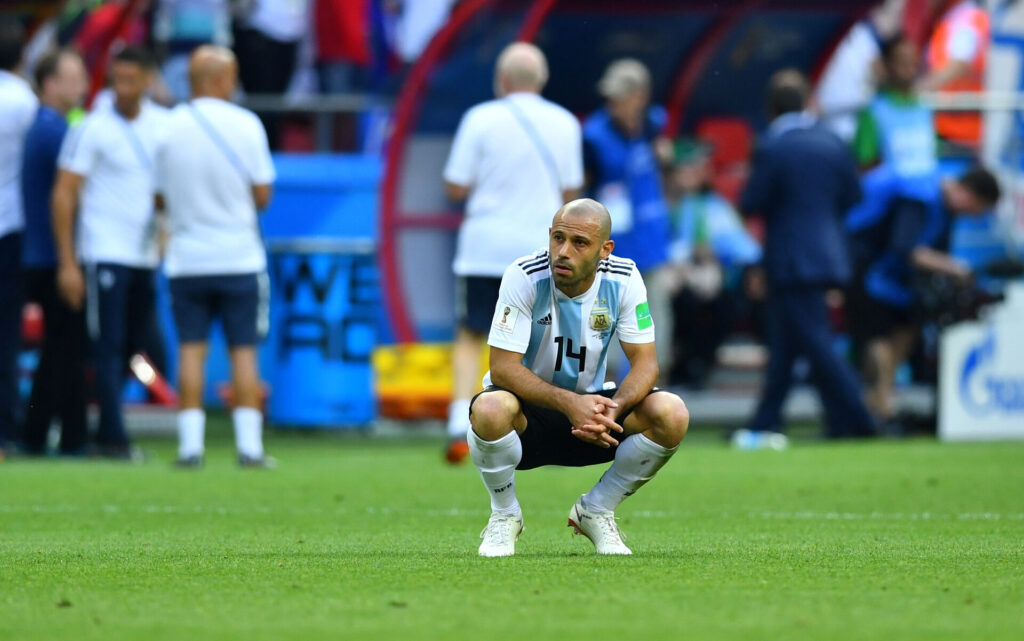 Javier Mascherano sidder på hug.