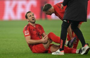 Harry Kane tager sig til sit ben efter skaden mod Dortmund.