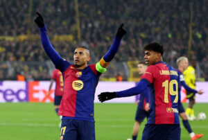 Raphinha løfter begge arme efter en scoring ved siden af Lamine Yamal