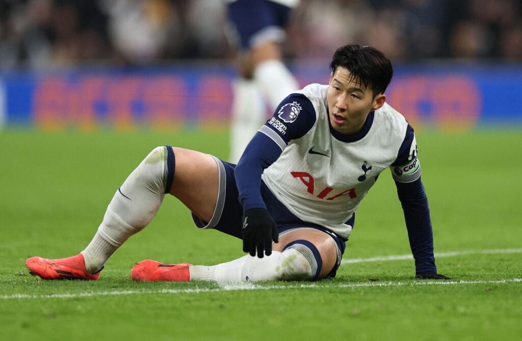 Son ligger på græsset efter aktion for Tottenham.