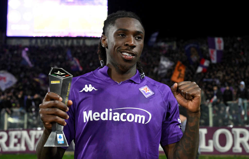 Moise Kean står med knyttede næver og et trofæ i en Fiorentina-trøje.